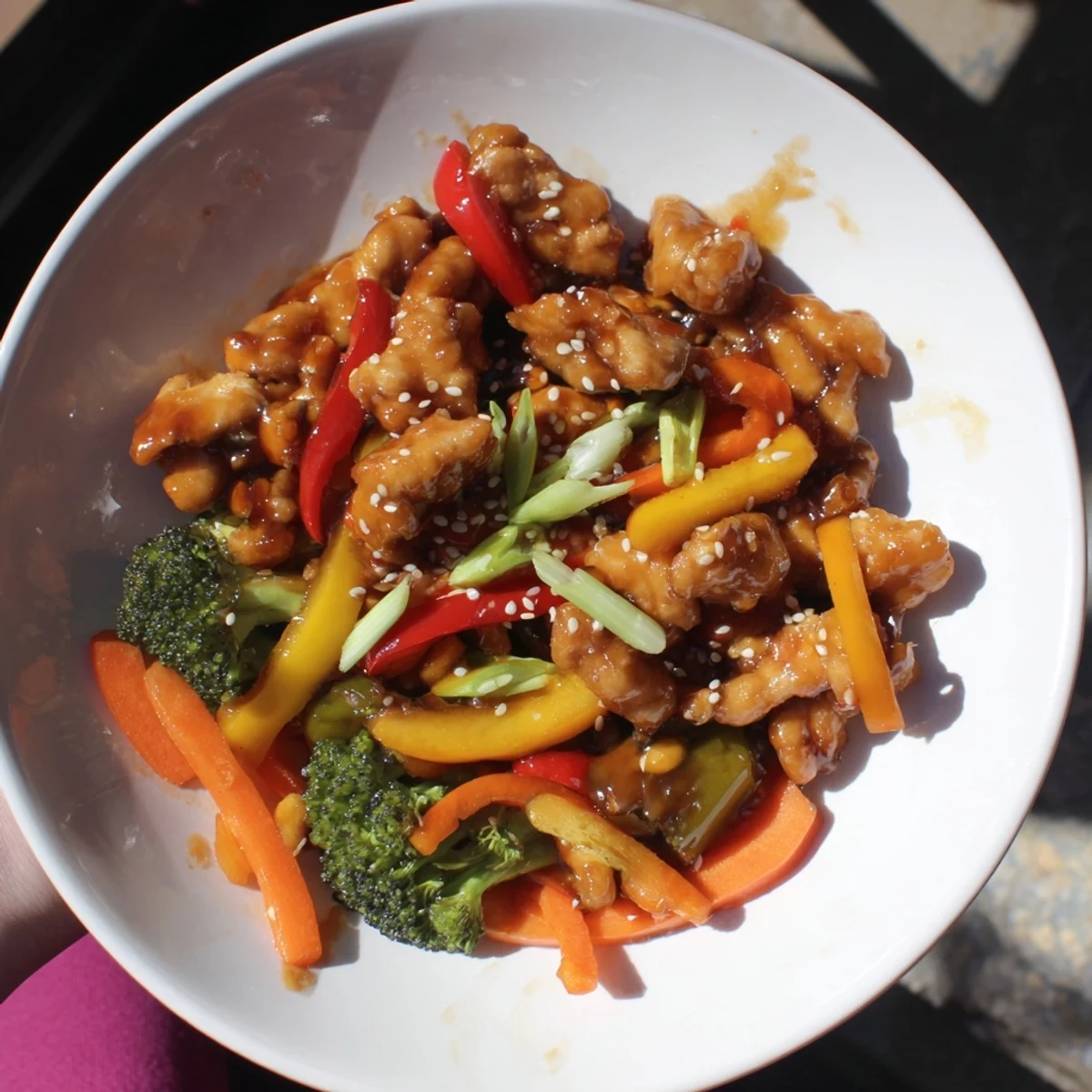 Golden chicken stir-fry with rice, featuring colorful vegetables in a thick, savory sauce.
