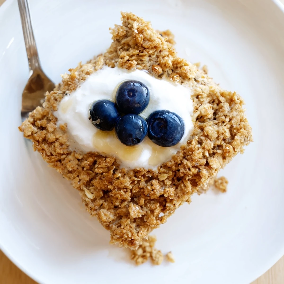 Fluffy baked Protein Pancake Oats, golden brown, served with a sweet drizzle and fresh blueberries.