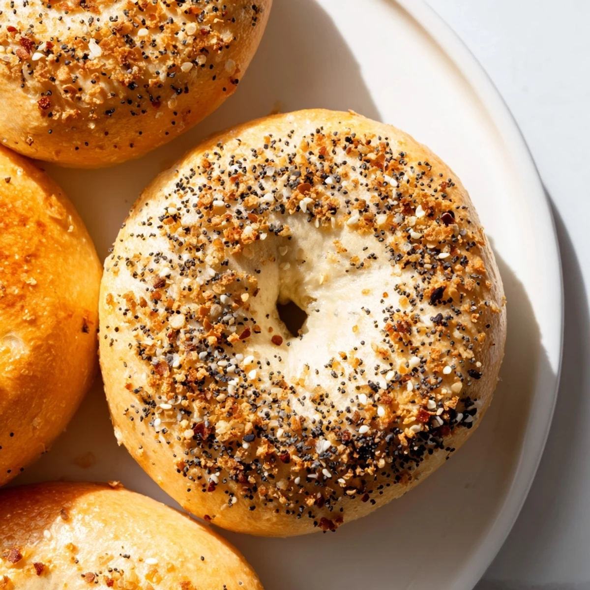 Freshly baked, golden Everything Bagel Yogurt Bagels topped with flavorful everything seasoning, ready to enjoy.
