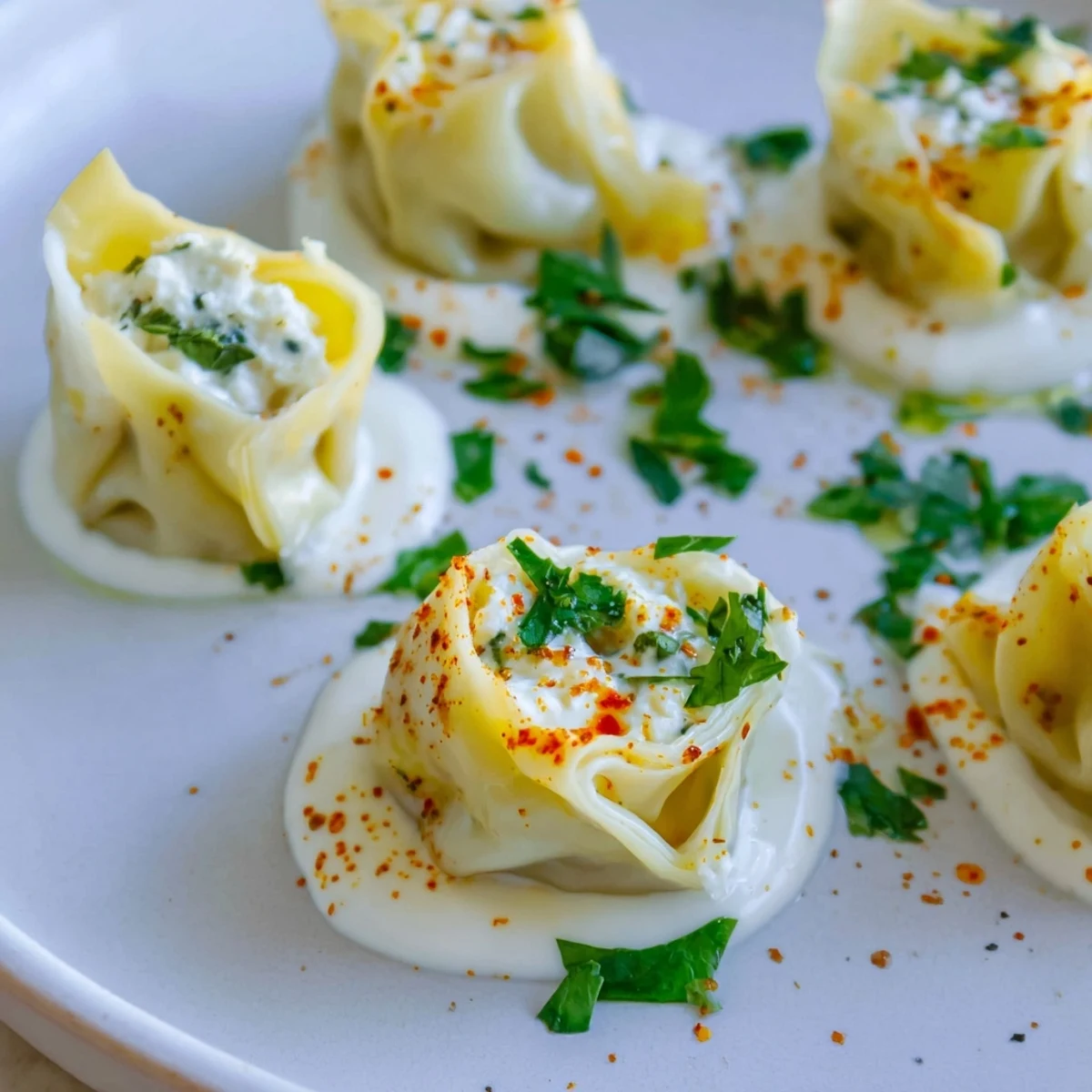 Close-up of golden, cooked Turkish cheesy manti, overflowing with a creamy cheese filling.