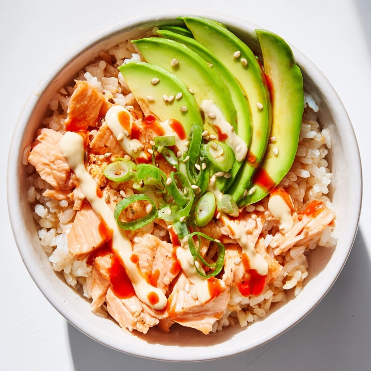 Close-up of a colorful Emily Mariko salmon rice bowl, showcasing flaky salmon and creamy avocado.