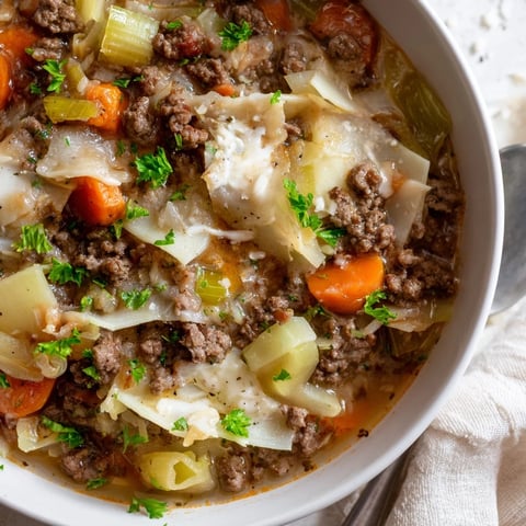 A warm bowl of gluten-free lasagne soup topped with drizzled truffle oil.  