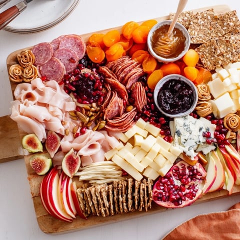 Autumn “Chaos” Charcuterie Board featuring vibrant cheeses, fruits, and meats for festive gatherings.  