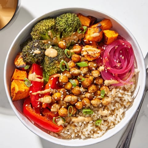 Vibrant grain bowls topped with bold sauce drizzle for a tasty vegetarian meal.  
