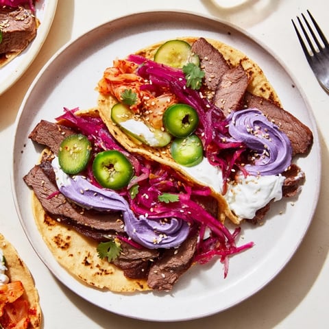Vibrant Global Street-Food Fusion Tacos topped with ube crema and fresh veggies.  