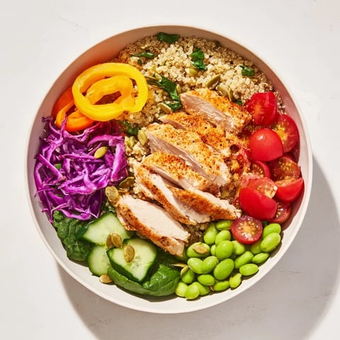 Vibrant healthy meal-prep bowls filled with colorful veggies, grains, and zesty dressing.  