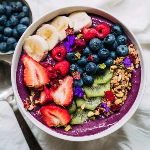 Colorful vibrant smoothie bowls topped with fresh fruits and crunchy pistachios.  