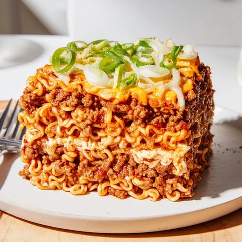 Hearty spicy ramen lasagna layered with flavorful pork and creamy cheese blend.  