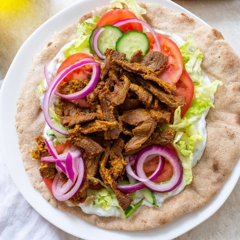 Juicy beef shawarma wraps, filled with vibrant veggies and drizzled with creamy yogurt sauce.