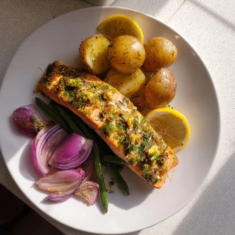 Golden, flaky Lemon Herb Salmon & Potato Sheet Pan with roasted vegetables and lemon wedges.
