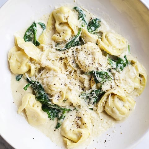 Creamy Spinach Alfredo Tortellini with vibrant green spinach and Parmesan for a cozy Italian meal.