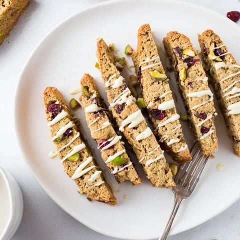 Golden, twice-baked white chocolate cranberry pistachio biscotti with drizzled white chocolate, ready to enjoy.