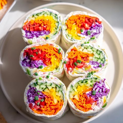 Rainbow Veggie Christmas Lights Wrap Pinwheels show a beautiful array of colorful, fresh vegetables rolled in a tortilla.