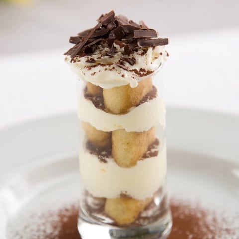 Countdown Tiramisu Shots in clear shot glasses, layered with creamy mascarpone and cocoa dusting.