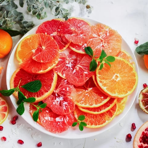 Vibrant fruit board: Citrus slice garland platter, featuring bright orange, pink, and yellow citrus arranged artfully.
