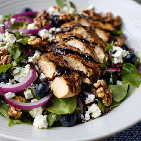 A colorful Blueberry Goat Cheese Chicken Salad with glistening balsamic glaze and fresh blueberries.
