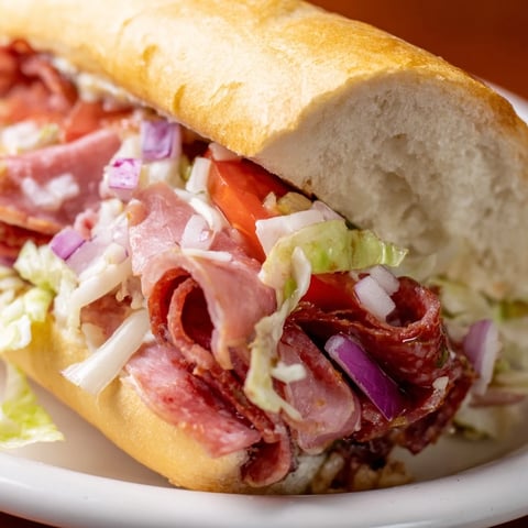 Chopped Italian Grinder sandwich overflowing with meats, cheese, and a vibrant Italian dressing.