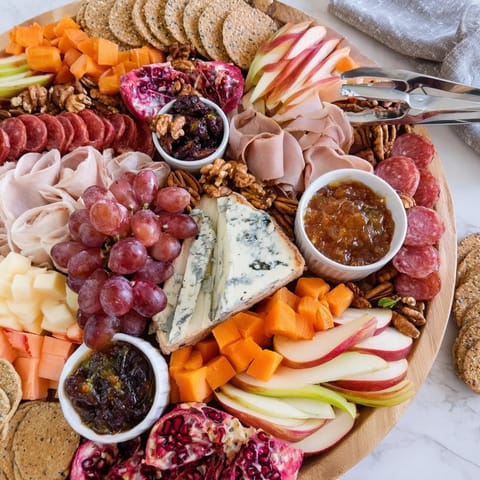 A beautifully arranged Autumn “Chaos” Charcuterie Board bursting with seasonal flavors and colors.  