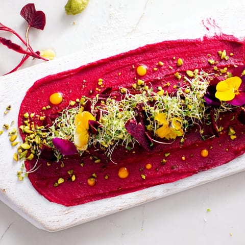 The visually striking "Modernist Stripe" appetizer includes a beet purée stripe with carrot, avocado, and beautiful edible embellishments.
