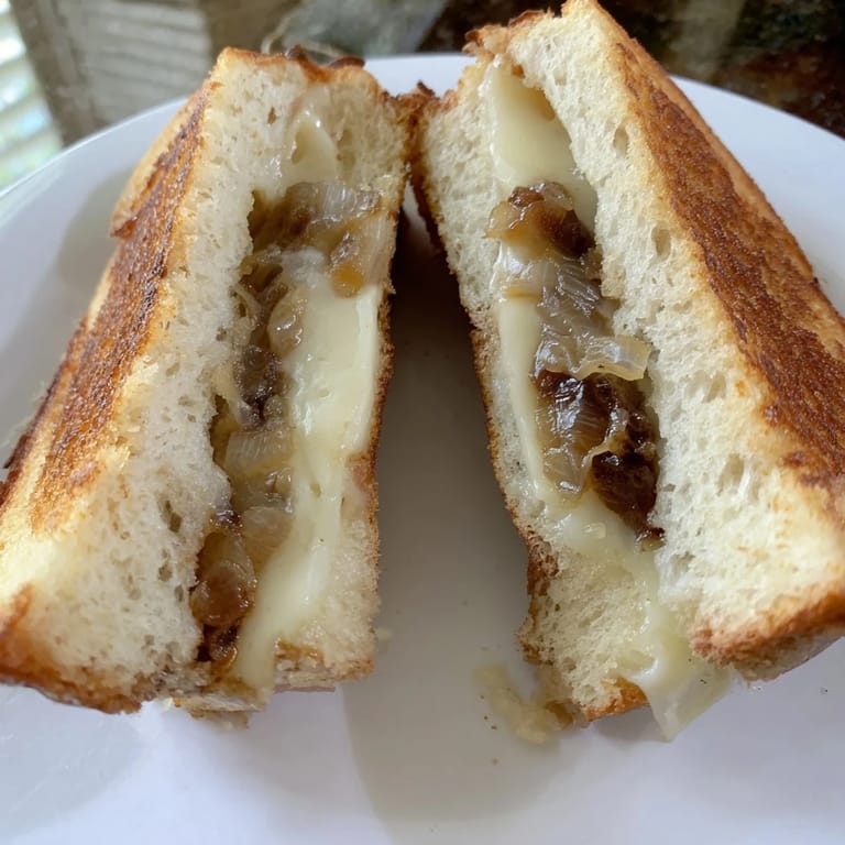 Melting cheddar and jammy onions peek from crisp golden bread in this comforting homemade caramelized onion grilled cheese.