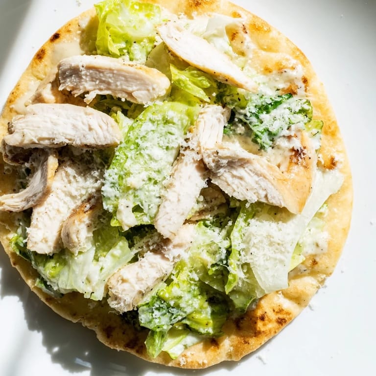 This Chicken Caesar Flatbread pairs juicy grilled chicken and crunchy romaine on a golden crust, finished with Caesar dressing and optional cherry tomatoes.