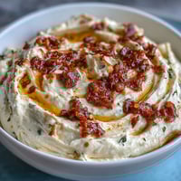 Creamy Calabrian chili cream cheese spread with vibrant red chili flecks and smooth texture.  