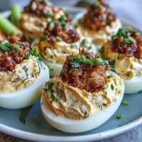 Deviled egg chicks with cute carrot beaks and peppercorn eyes on a serving platter.  