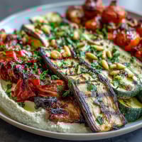 Colorful grilled veggie platter with creamy hummus, perfect for healthy summer meals and picnics.  