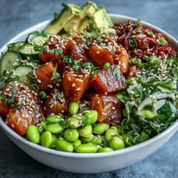 Vibrant salmon poke bowl with creamy avocado, bright edamame, and fresh veggies.